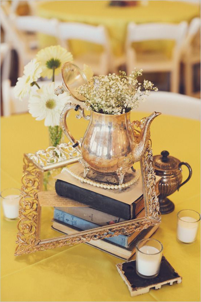 decoration de table vintage, livres anciens, théière dorée, nappes de table jaunes, chaises blanches