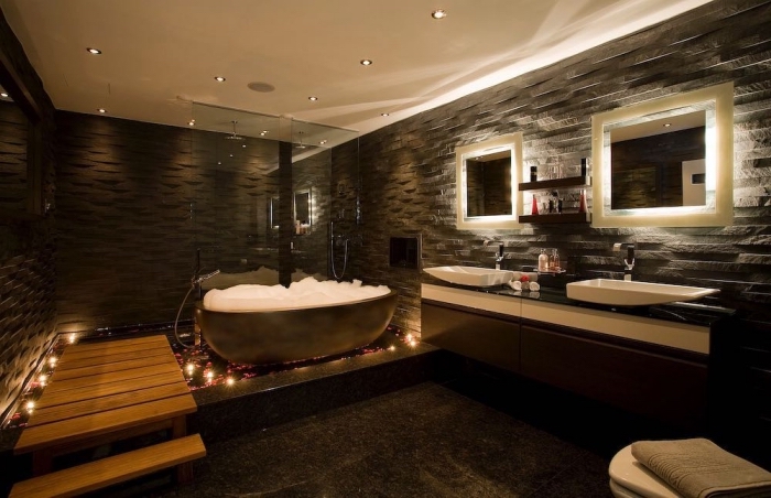 idée salle de bain zen aux murs en pierre foncé et plafond blanc avec marches en bois, agencement salle de bain baignoire et cabine de douche