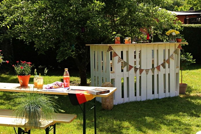 meuble palette bois pour le jardin ou la terrasse, bar de jardin en palettes décoré d'une guirlande à fanions installé à côté du salon de jardin