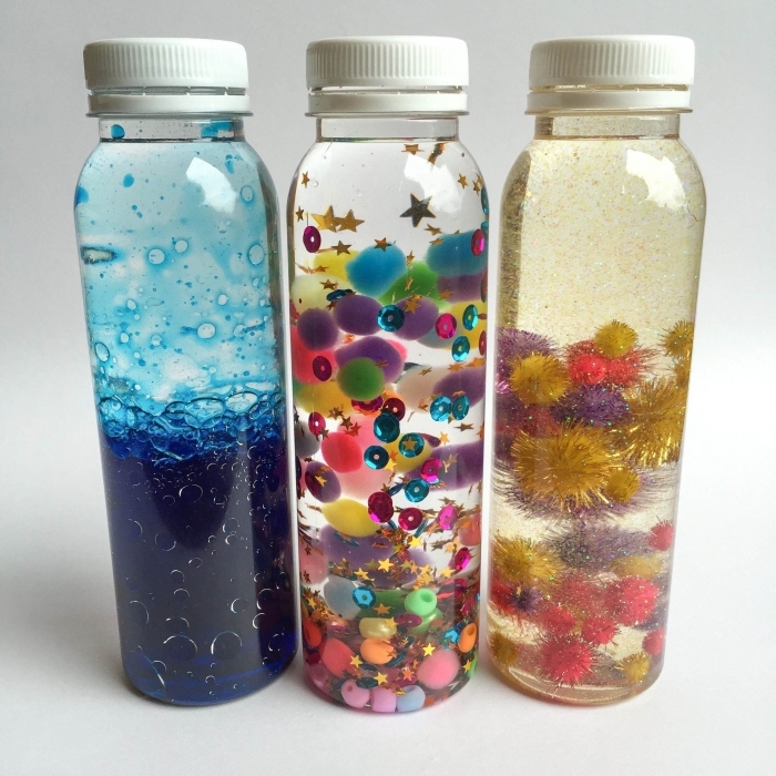 modèles de jouet montessori DIY, exemple de bouteille en verre remplie d'eau et d'huile pour bébé avec colorant bleu effet océan