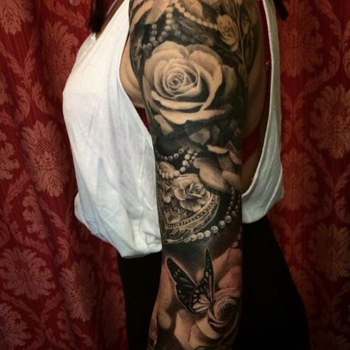 tatouage bras femme roses et colliers, papillon, fleurs de rose, débardeur blanc, idée tatouage noir et blanc