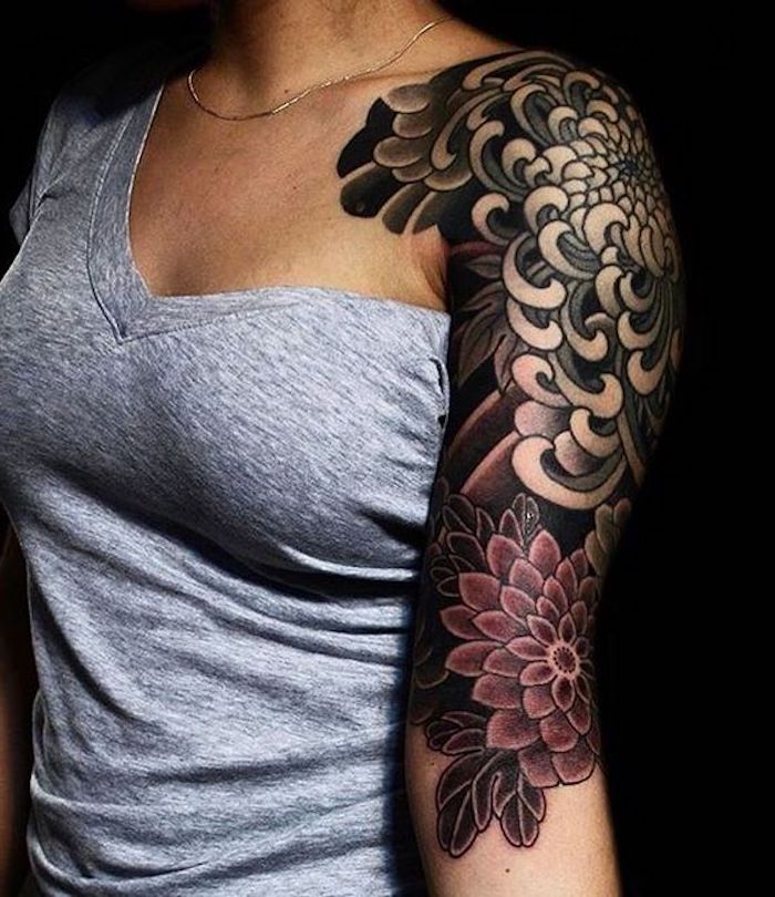 tatouage femme bras et épaule, débardeur gris, tatouage fleur dahlia, collier subtil, tatouage noir et rouge