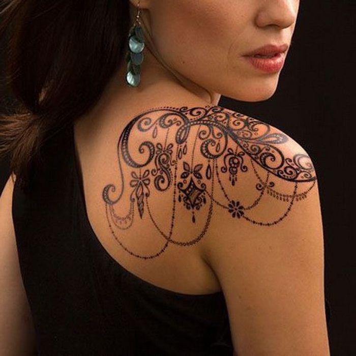tatouage épaule femme, tatouage pendentifs, boucles d oreille perlées, motifs floraux, débardeur noir