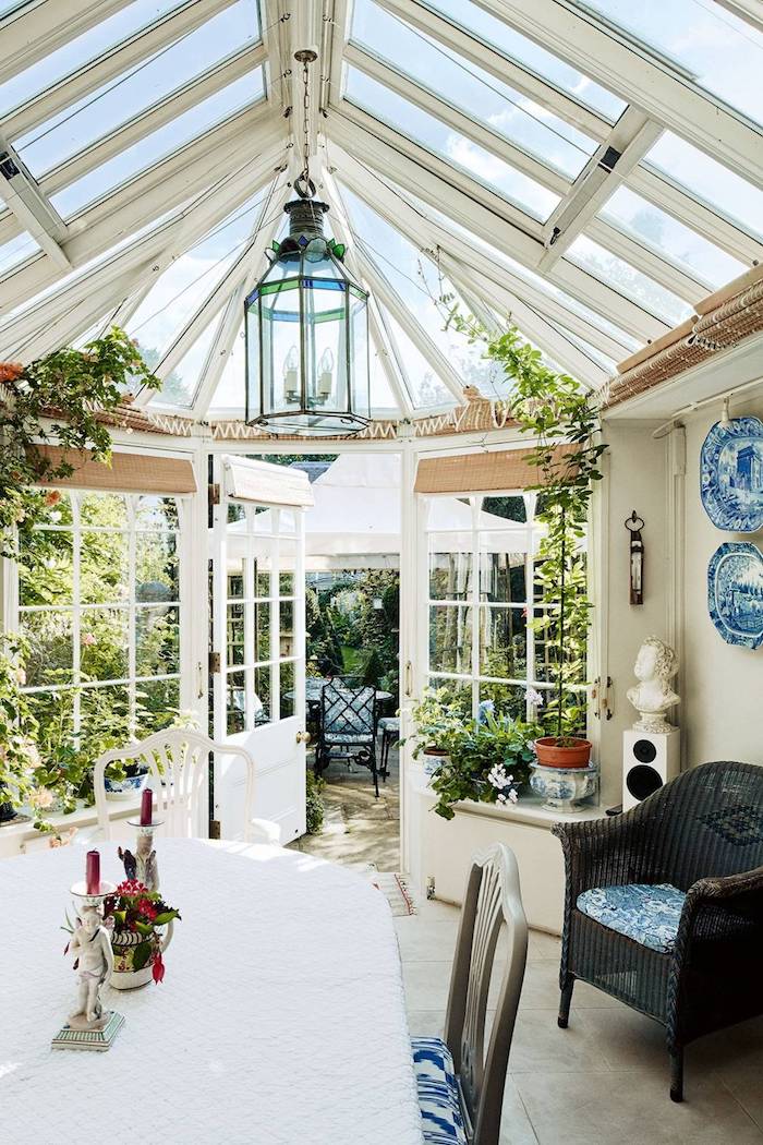 idee veranda victorienne blanche avec de petites fenetres de toit, coin salle à manger et chaise de rotin