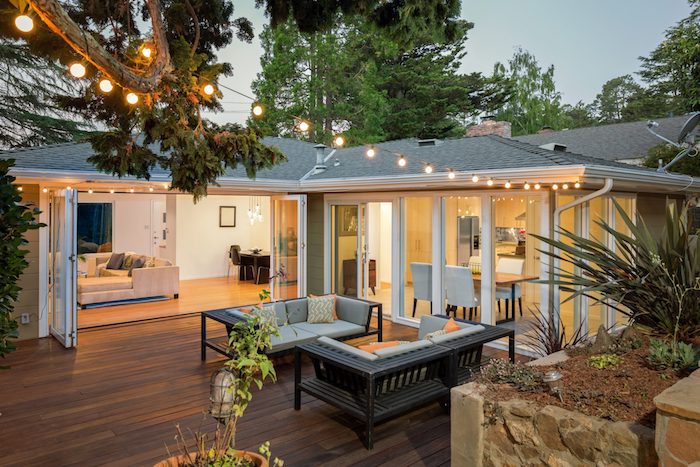 idee d extension maison enorme, batiment attenant ouvert sur une terrasse de bois avec deux bancs de bois, deco guirlande lumineuse exterieure
