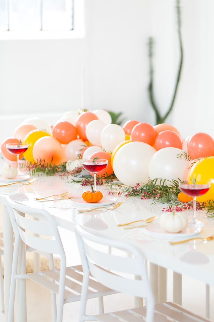 idee deco table avec ballons, verres à vin, mini citrouilles, guirlande de ballons comme chemin de table, ustensiles dorés