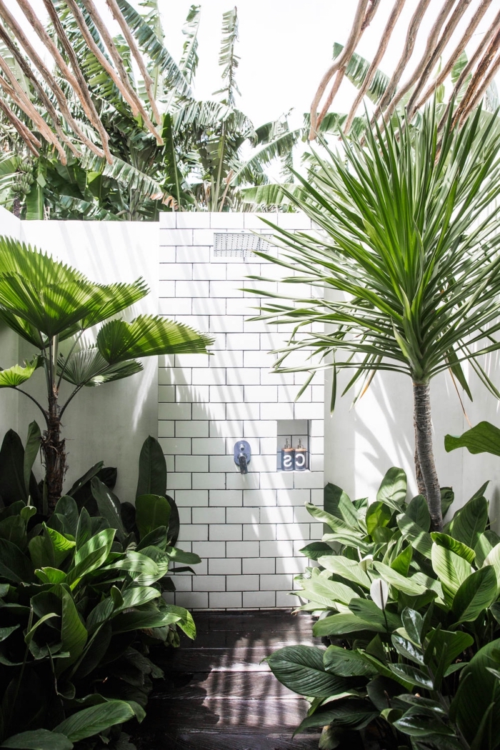 exemple comment décorer une salle d'eau extérieure avec toiture en bois exotique et murs en carreaux blancs