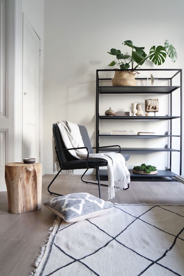 Chaise coin de lecture, étagère industrielle, table basse bois flotté, tapis noir et blanc, interieur moderne
