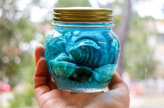 fabriquer un jouet montessori, exemple recyclage contenant en verre, diy objet éducatif en verre rempli de coquillage