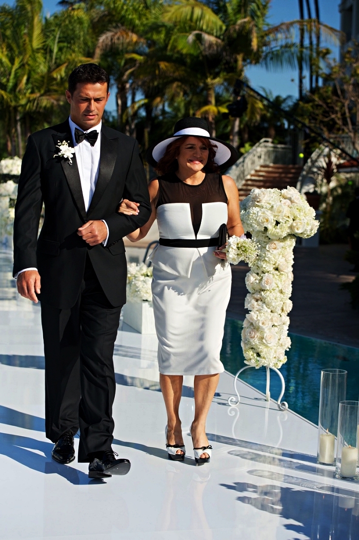 robe péplum en blanc et noir avec empiècement en tulle noire accompagnée d'un chapeau de mariage assorti, tenue mariage femme 50 ans pour la mère de la mariée