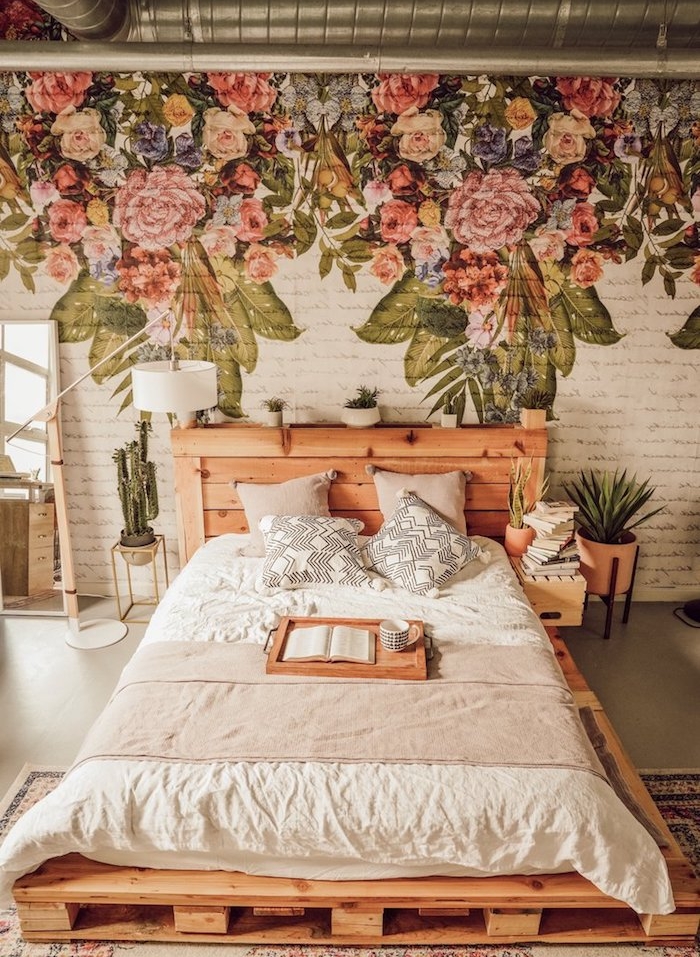 lit en palette avec tete de lit bois diy, mur décoré de dessin imprimé floral sur briques blanches, pots de plantes vertes en guise de chevet