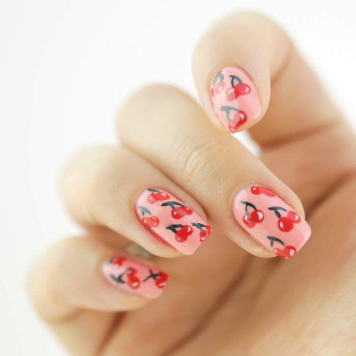 ongles nail art avec cerises, fond rose et cerises rouges, ongles carrés