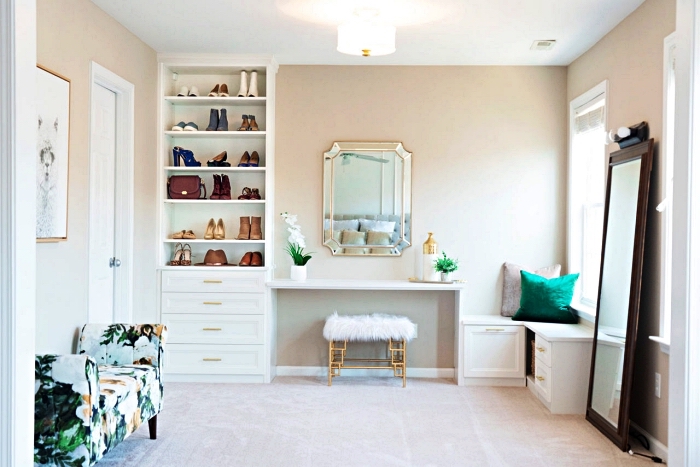 armoire a chaussure semi-ouvert à côté de la coiffeuse dans une chambre à coucher en blanc, or et vert émeraude