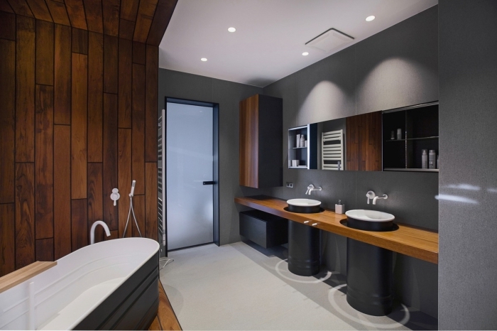 modèle de salle de bain grise au plafond et sol blancs avec revêtement mural à effet bois, modèle de baignoire autoportante blanc et bois
