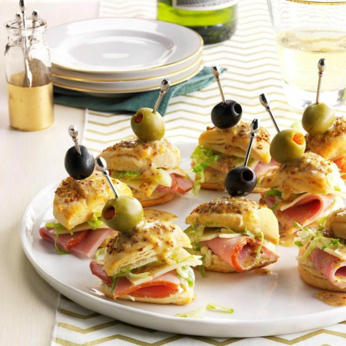 mini sandwiches avec jambon, brochettes au jambon et au fromage, olives, assiette blanche, brochette apéro