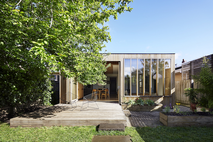 agrandissement bois abritant petit studio avec cuisine ouverte sur salle à manger et salon, sur terrasse en bois
