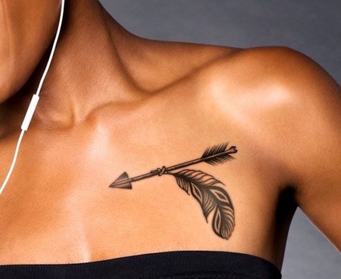 tatouage élégant en noir, flèche et plume, symboles indiens tatoués sous la clavicule de jeune femme