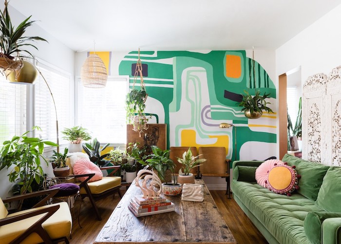 canapé vert, table basse bois brut, fauteuils jaunes, mur d accent repeint de motif géométriques, plantes vertes