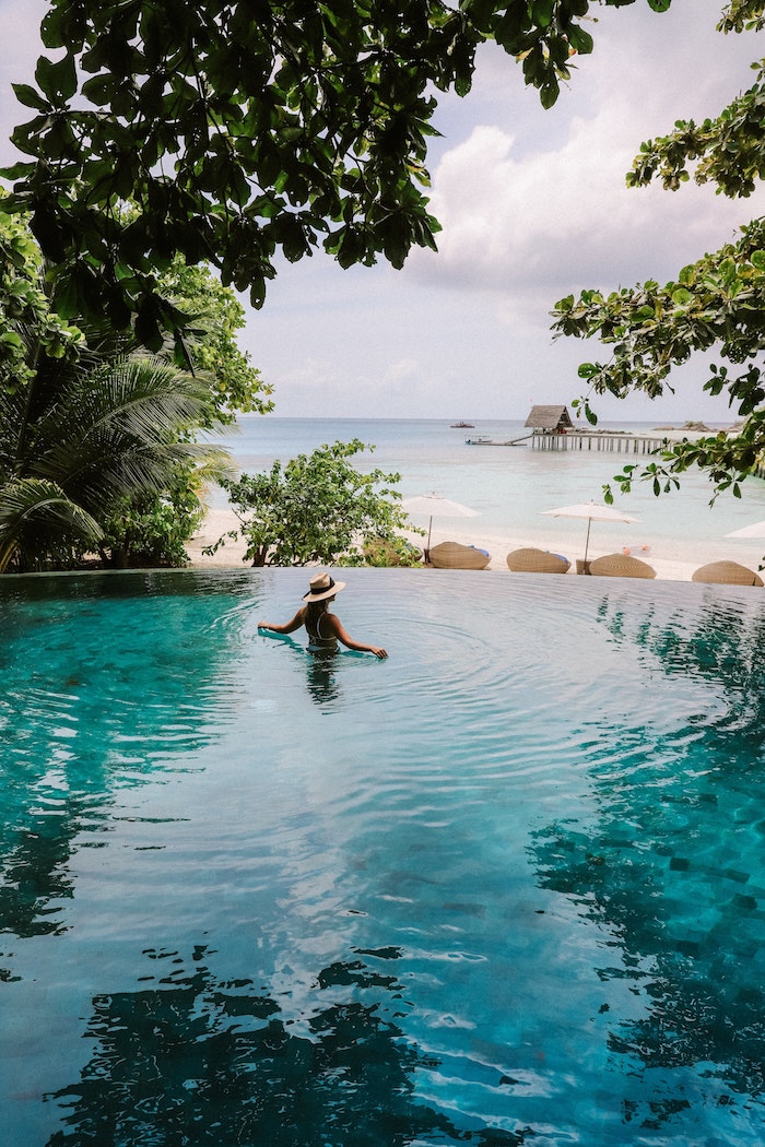 Femme dans piscine infinie, vue de la mer fond d'écran tropical, paysage paradisiaque été 2019, paradis d'été pour les vacances 