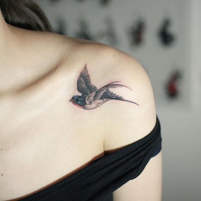 petit tatouage épaule en rouge et noir, oiseau en vol, motif symbole de liberté et de bonheur