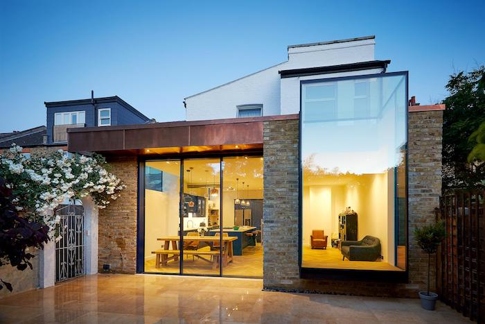 petit studio en extension d une maison contemporaine avec cuisine blanche, bleu et bois ouverte sur coin repas et salon minimaliste