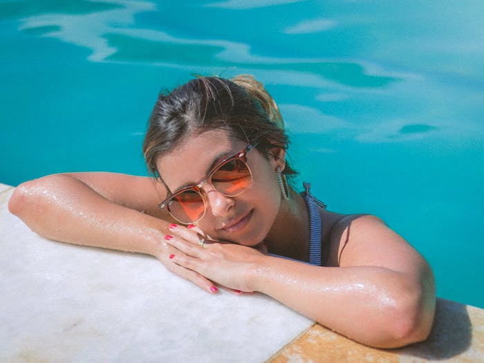 Femme dans le piscine avec lunettes de soleil oranges, image de paysage, fond d'écran été, beauté stupéfiante