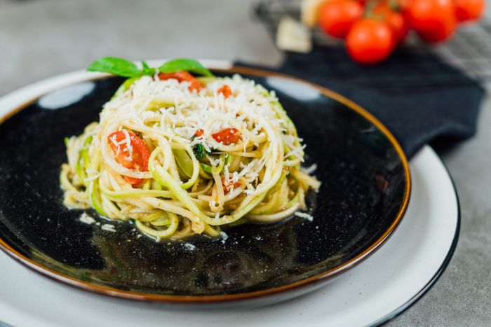 spaghetti de légumes aux courgettes à la sauce tomate, basilic et pesto avec du parmesan râpé