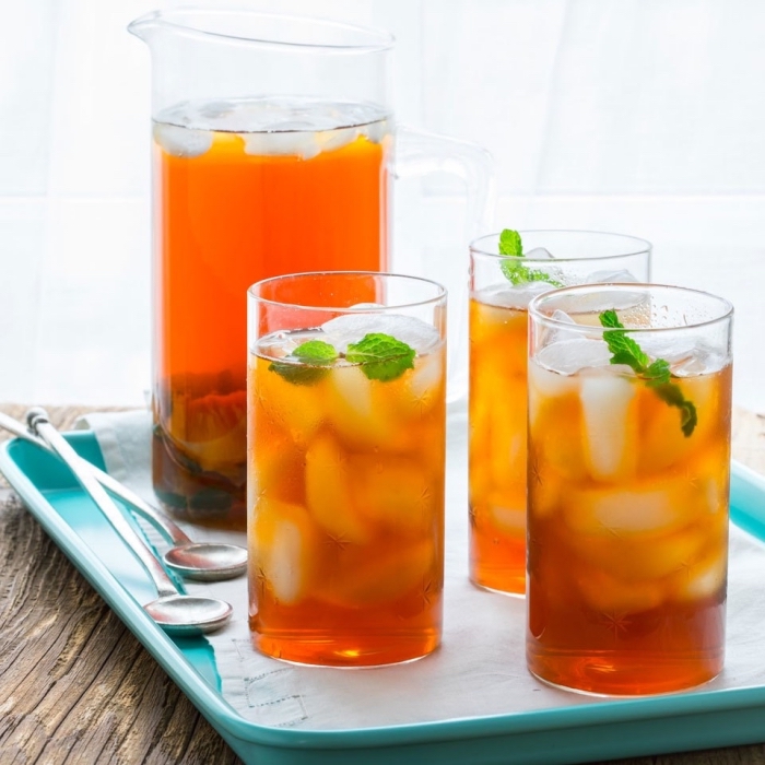 boisson saine au thé vert refroidi avec tranches de pêche et miel, comment servir un thé glacé avec feuilles de menthe