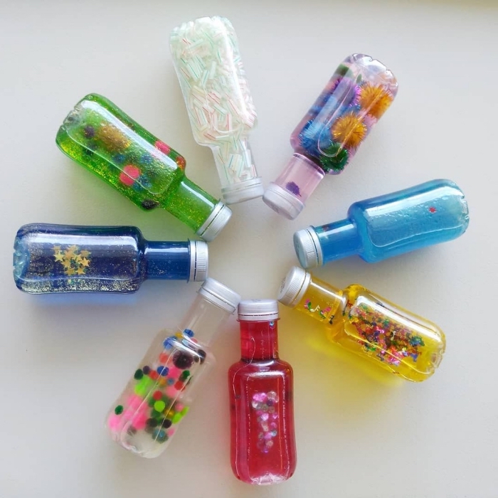 exemples de bouteilles sensorielles DIY, modèle bouteille en verre remplie d'eau colorée et de paillette, idée jouet bébé diy