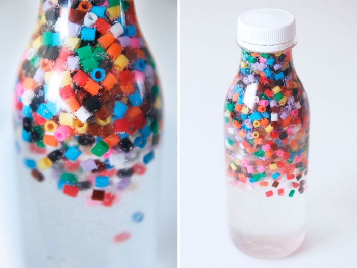 comment faire une bouteille de retour au calme, remplir un contenant en verre avec de l'eau et de petites figurines jouets