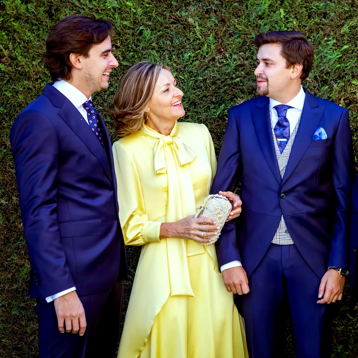 robe mere du marie femme 60 ans tenue jaune avec deux hommes costumes bleus