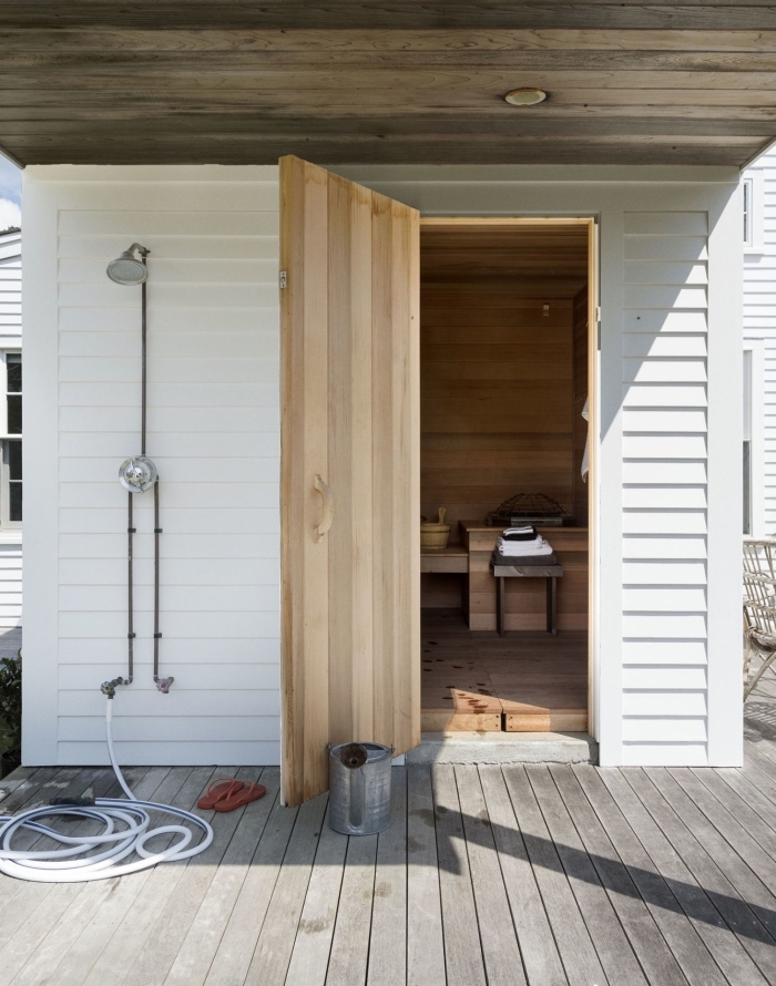modèle de salle de bain extérieure aménagée sur une terrasse en bois avec toiture bois et douche exterieur en métal