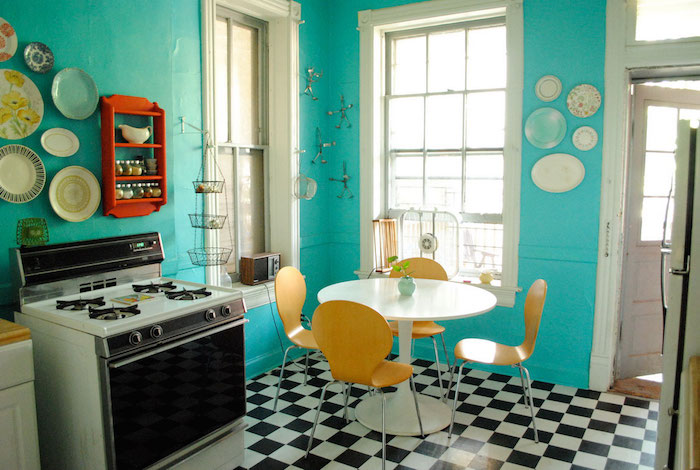 Bleu cuisine rétro avec carrelage de sol en carré, four vintage cuisinière, jaunes chaises et table à manger ronde
