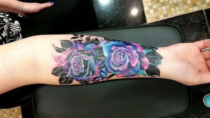 tatouage roses colorées, feuilles noires, tatouage femme avant bras, deux roses en lilas et bleu