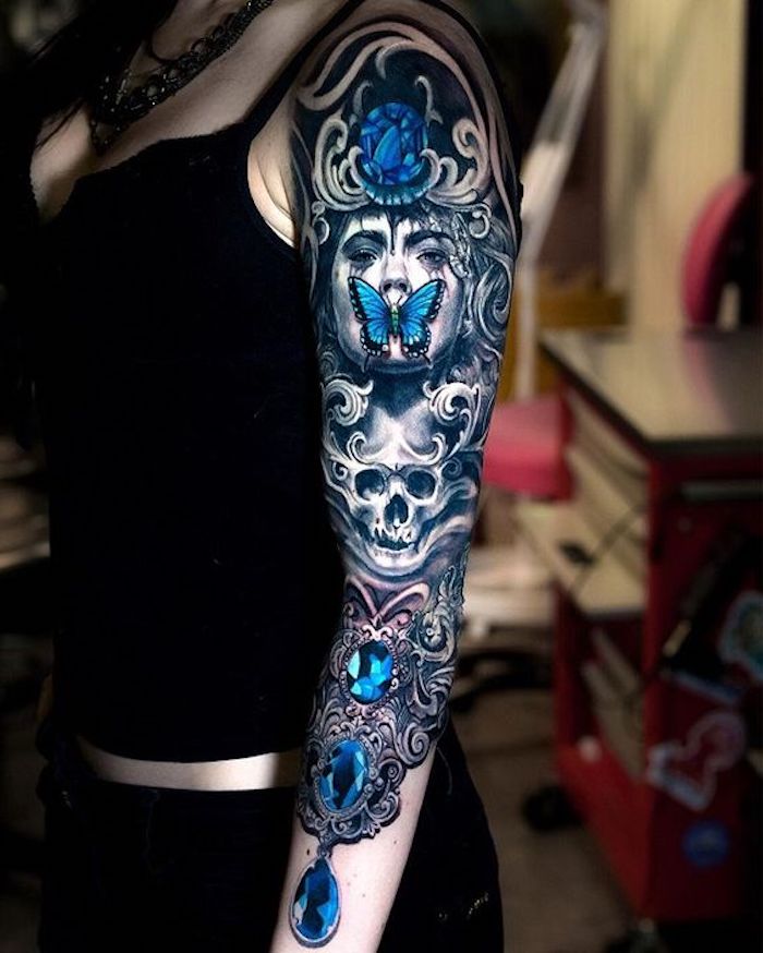 tatouage style gothique, pierres précieuses bleues, tête de mort, figures tatouées et fond noir