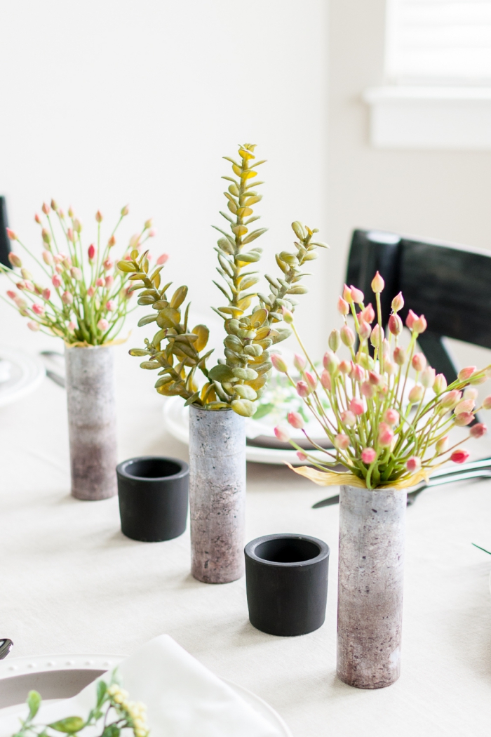 vases avec papier peint look béton, succulentes, fleurs roses, tasses en verre; idee deco table