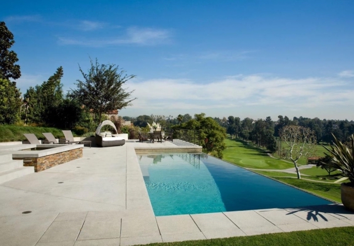 design minimaliste dans un jardin avec terrasse béton et grande piscine, meubles de jardin moderne à design tressé