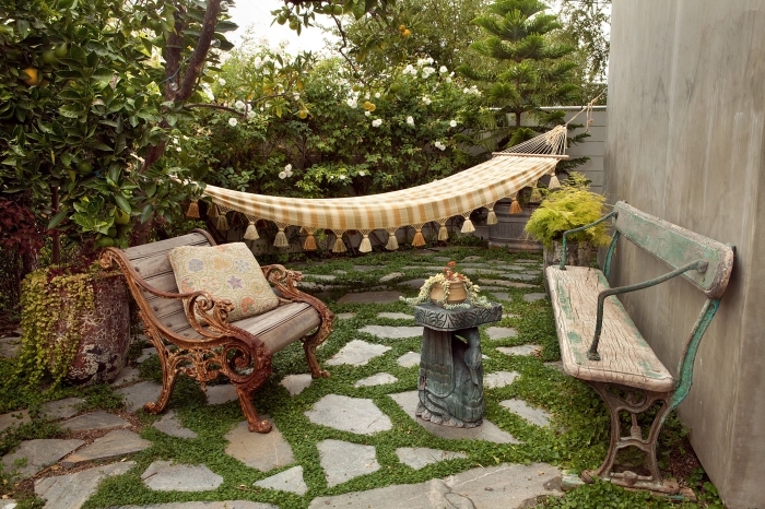 déco bohème chic dans une cour arrière avec gazon et dalles, modèle de chaise bois brut style rétro chic pour jardin