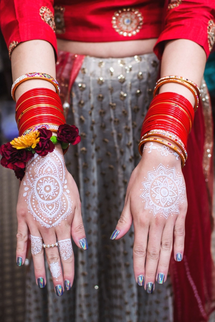 tatouage henné main symbolique, exemple comment décorer ses mains avec dessins blancs à effet bijoux mandala
