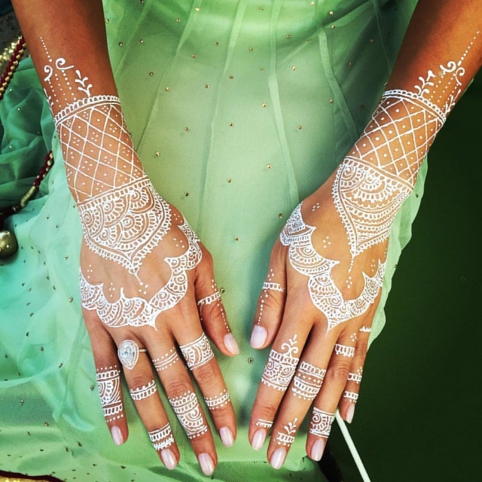 photo de henné sur main, modèle de tatouage temporaire sur mains aux motifs mandala, idée tattoo blanc temporaire