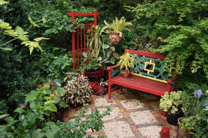meubles de jardin en bois peint en rouge, déco petit espace extérieur avec banc et plantes vertes, jardin d'agrément