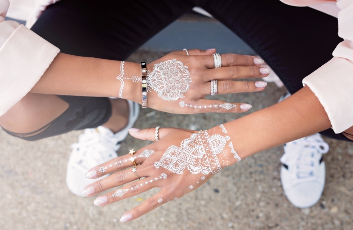 modele henné main à design mandala blanc avec petites flèches vers les doigts, idée art corporel temporaire