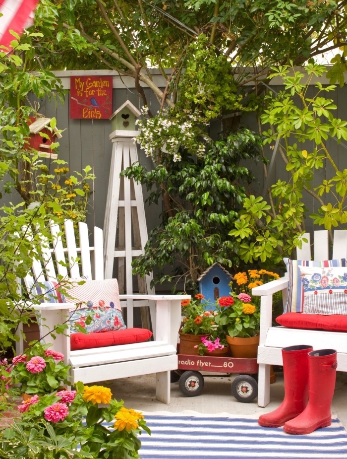 comment aménager son jardin, cour arrière à espace limité avec clôture bois et meubles en bois blanc décoré avec accessoires rouges