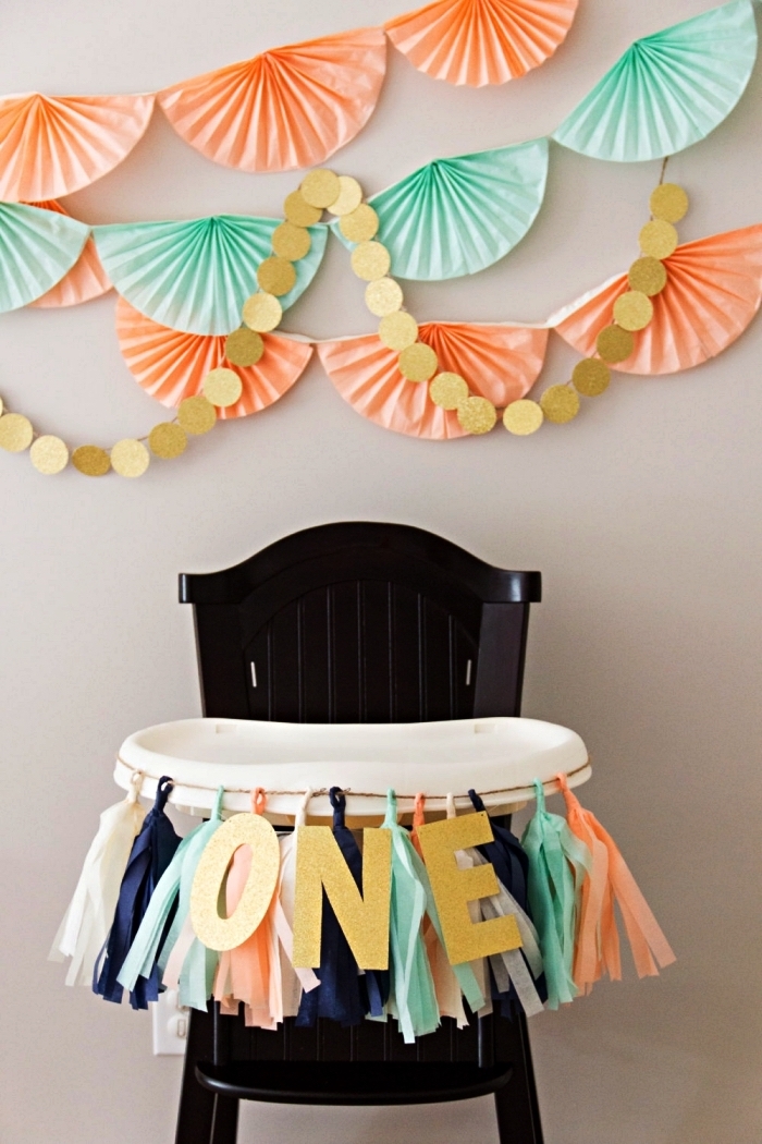 décoration d'une chaise haute pour le premier anniversaire du bébé, déco murale de rosaces en papier en tons pastel, idée déco anniversaire 1 an à faire soi-même