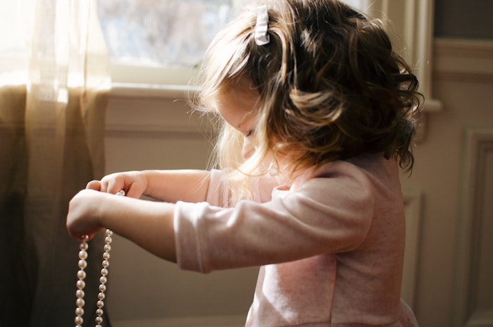 cheveux-bouclés-blonde-petite-fille-adorable-qui-joue-avec-perles-collier-coiffure-petite-fille-mariage-coiffure-facile-a-faire-enfant Petite fille cheveux bouclés, coiffure facile a faire, coiffure pour fillette décontractée chic, fille qui joue avec les perles de sa mère