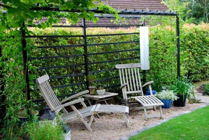 décoration jardin extérieur, modèle de petit jardin avec pelouse artificielle et bordure en pierre, meubles de jardin en bois