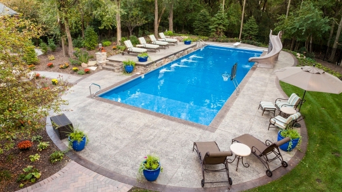 exemple de terrasse de piscine en béton, aménagement cour arrière avec jardin vert et piscine rectangulaire