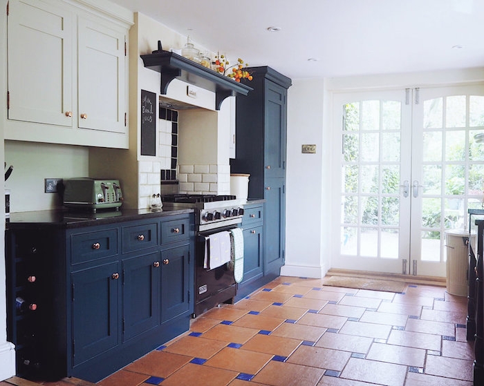 mobilier de cuisine bas bleu marine foncé et mobilier haut blanc, carrelage sol orange et bleu 