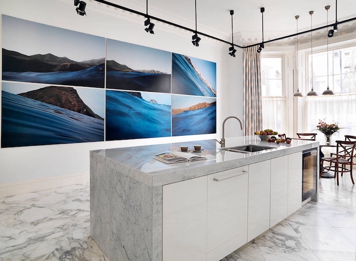 mur de cadre paysage bord de mer pour décorer le mur d une cuisine blanche et grise avec sol et plan de travail marbre, éclairage de spots