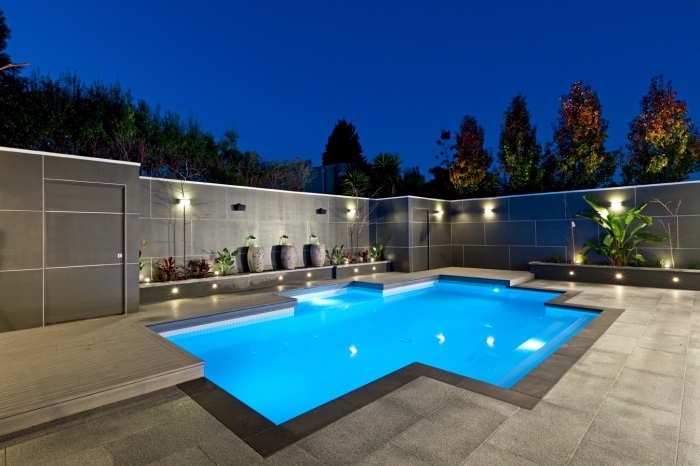 aménagement extérieur d'une maison moderne avec dalles gris anthracite et terrasse bétonnée autour d'une piscine